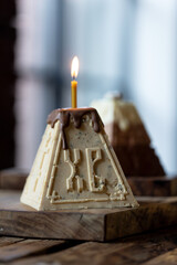 Beautiful and delicious cottage cheese Easter cake with walnuts and candles on a wooden background