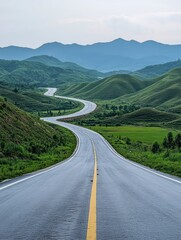 Naklejka premium Driving on Winding Road Through Green Hills and Distant Mountains