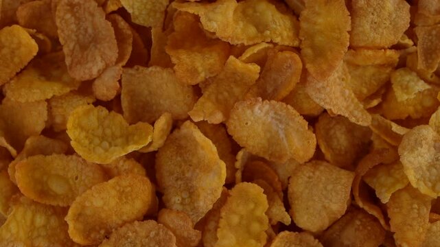 Closeup top view of a spinning pile of Corn Flakes with clear dry textures