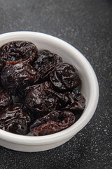 Dried prunes smoked drained plum gourmet food background on the table rustic food top view copy space keto and paleo diet vegetarian and vegan food