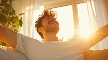A young man waking up in bed, stretching his arms with a relaxed smile as warm morning sunlight streams through the window.