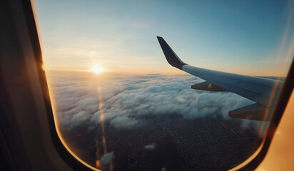 An early morning flight with the golden sunlight reflecting off the airplane wing, soaring above the clouds with a breathtaking city view below. The peaceful sky.