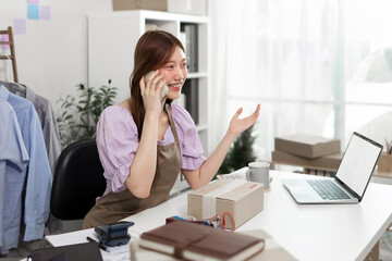 Obraz premium Young woman talking business on mobile phone in office, happy face