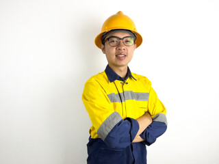 Portrait of Asian engineer with yellow helmet crossing arms on white background