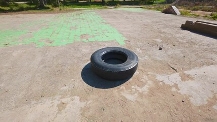 Large Truck Tire Used for CrossFit Workouts in Abandoned Park - Powered by Adobe