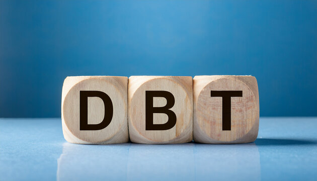 Wood cubes with abbreviation DBT on table. Dialectical Behavior Therapy. Psychology and therapy