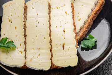 Sandwich soft cheese Camembert or Brie fresh delicious gourmet food background on the table rustic...