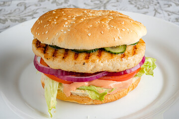 Succulent grilled chicken patty topped with crisp lettuce, juicy tomatoes, and onions on a bun