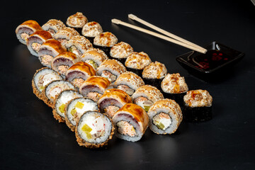 A stunning display of colorful sushi rolls neatly arranged on a dark surface