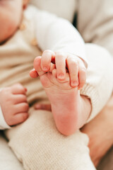 Close-up of baby's feet in mother's hands.