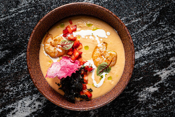 This vibrant bowl contains creamy shrimp soup with fresh veggies and herbs for a delightful dish