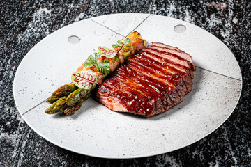 Grilled steak with fresh asparagus and herb garnishes is a culinary delight