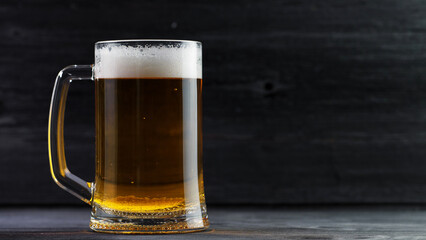 Beer mug on dark wooden table. Copy space