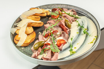 Pastrami slices, dried beef meat with vegetables and a delicate sauce, delicious antipasti
