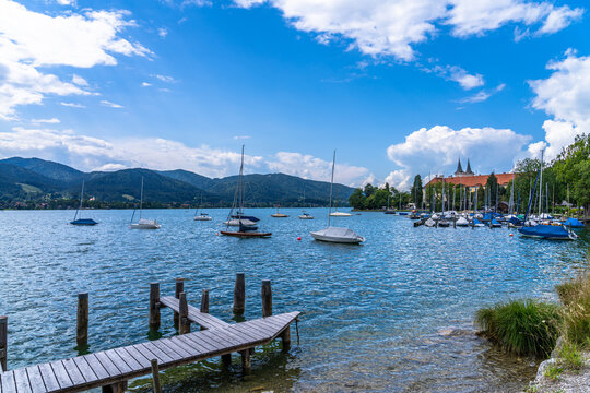 Stunning panorama view of Tegernsee lake with Tegernsee town including St. Quirinus parish church, on a sunny summer day with blue sky cloud, Bavaria, Germany