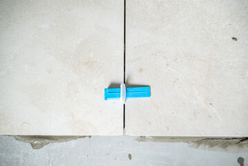 Focus sur la pose de carrelage. Zoom sur un croisillon entre deux carreaux de carrelage.