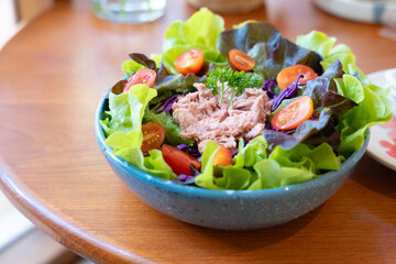 Tuna salad in the ceraamic bowl on the wooden table