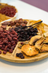 Dried fruit slices and raisin on a round wooden plate. Close up shot. Healthy snack concept