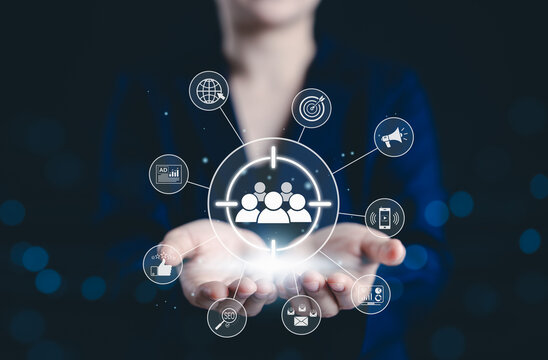 Digital marketing and target audience concept. Business professional holding digital interface with icons representing audience targeting, advertising, SEO, social media, online marketing strategies,