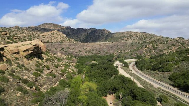 Aerial over Corrigan Movie Ranch and public recreation park in the hills of Rocky Peak in Simi Valley, California. With the 118 Freeway and railroad tracks.