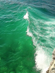 Emerald waters meet the shore, a captivating display of nature's power