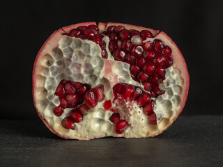 Delicious and fresh pomegranate, a bright fruit on a dark background