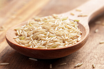 Long grain unprocessed basmati rice in a wooden spoon. Diet food. 