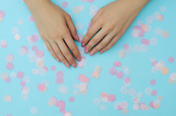 Women's nude manicure on a blue background. Beauty and health. Beauty procedure. Women's hands.