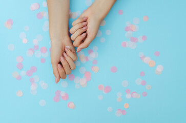 Women's nude manicure on a blue background. Beauty and health. Beauty procedure. Women's hands.