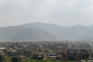 Cityscape of Kathmandu, the capital of Nepal, with mountains in the background and smog