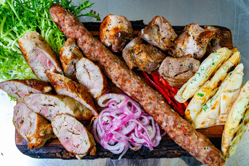 Delicious assorted grilled meats and fresh vegetables on a platter