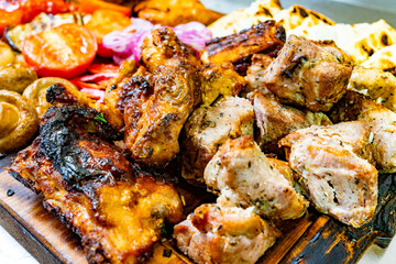 Delicious grilled meats and vegetables served on a wooden platter