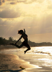Silhouette beautiful girl jumping on a beach