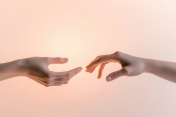 two hands gently reaching towards each other fingers slightly apart on plain soft-colored background warm light illuminating
