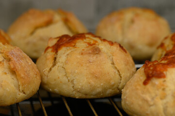 Freshly baked golden bread rolls cooling on a wire rack in a warm kitchen