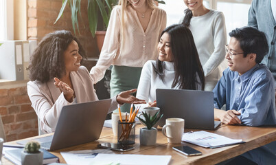 Close up of professional afro woman sharing business ideas with international colleagues in office