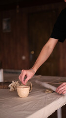 Young ceramicist making clay pottery in studio