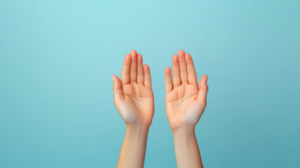 Obraz premium Close up of hands raised in gesture of inclusion, symbolizing communication and connection. soft blue background enhances focus on hands