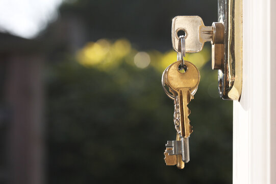 House keys in lock of door horizontal close up copy space