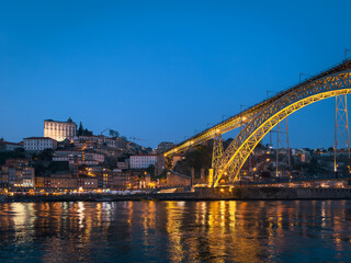 The iconic Dom Lu&iacute;s I Bridge, illuminated against the night sky, stands as a symbol of Porto s industrial heritage and architectural beauty.