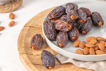 Medjool dates and almonds on a plate, showcasing a healthy snack option with rich textures and natural colors, perfect for nutritious eating and culinary inspiration