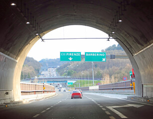 Fototapeta premium Exit of the Italian motorway tunnel with road signs for Florence or the city of Barberino del Mugello in Italy