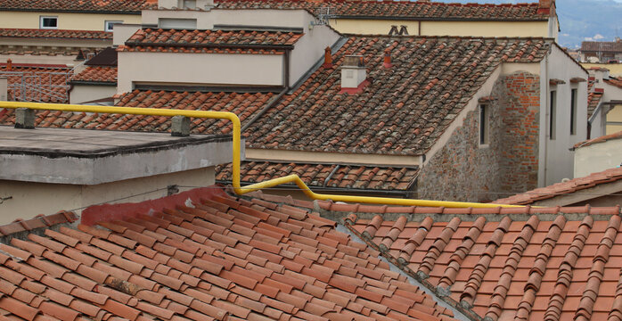 yellow methane gas pipe that runs above the roofs of houses to the user