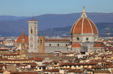 Fototapeta premium view of florence cathedral with the tall bell tower by artist giotto and the grand dome by architect brunelleschi with the tuscan hills in the background