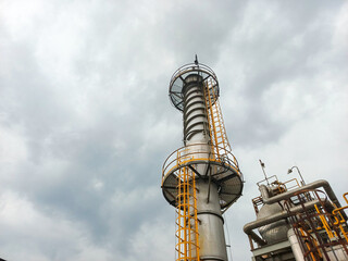 Low-angle view of chemical industrial refinery chimney against cloudy sky