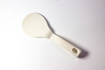white plastic rice paddle on a white background, for cooking or kitchen utensil
