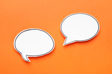 Blank speech bubbles on orange background, top view. Space for text