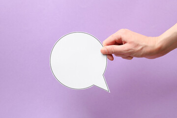 Woman holding blank speech bubble on lilac background, closeup. Space for text