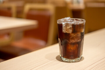 A glass of Cola on the table with bokeh background