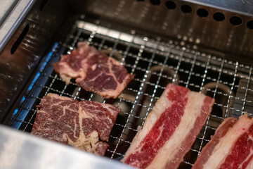 Korean Style Barbecue on stainless grill. BBQ rare meat with soft focus